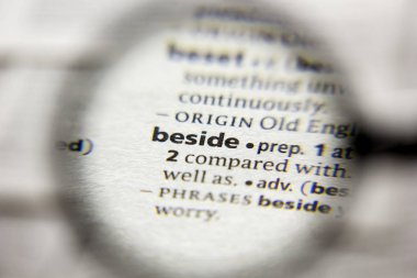 Sözlükte Yanındaki sözcük veya tümcecik.