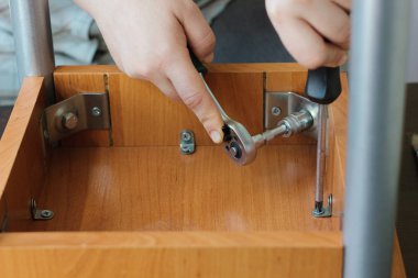 Lokma anahtar ile bir vida vidalama eller.