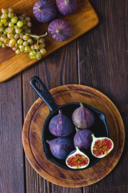 Ahşap masa üzerinde tava içinde taze ve olgun incir.