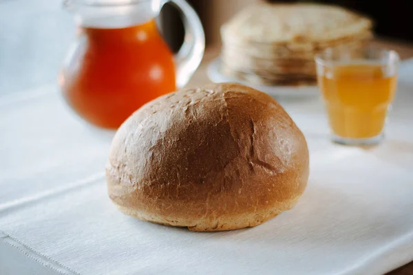 Φρέσκο ζεστό ψωμί σε λευκό τραπεζομάντηλο στο τραπέζι του εστιατορίου. — Φωτογραφία Αρχείου