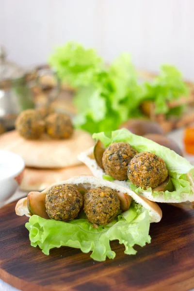 Bom falafel vegetariano em pão pita em tábua de madeira . — Fotografia de Stock