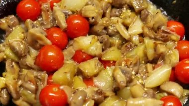 Olgun domates ve mantarların tavada kızardığı yakın çekim görüntüleri.