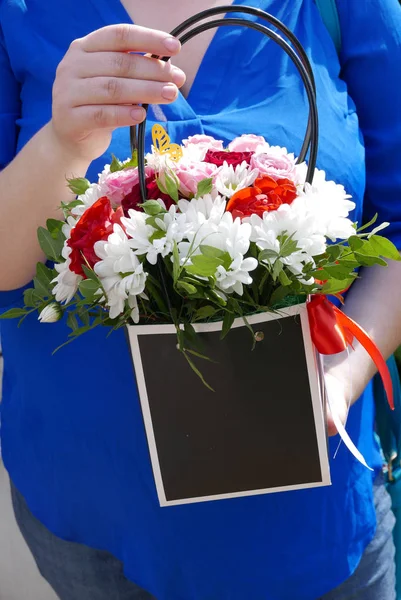 Woman holds flower bouquet in hands