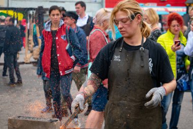 Ryazan, Rusya - 27 Temmuz 2019: Demirhane festivalinde kadın demirci çalışıyor.