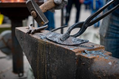 Demirci bir çekiç ile metal detay dokunarak