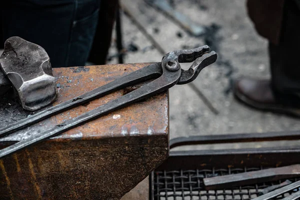 Pinças de metal sobre a bigorna - equipamento de ferreiro — Fotografia de Stock