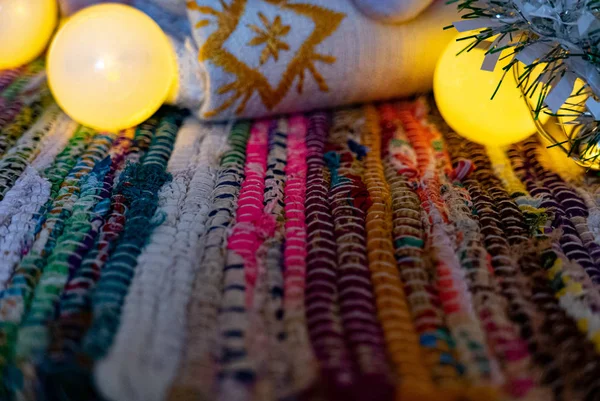 Рождественские гирлянды над цветным ковром . — стоковое фото