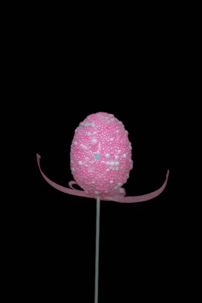 Un huevo de Pascua rosa en un palo con la cinta en una forma de manos quería abrazar. — Foto de Stock