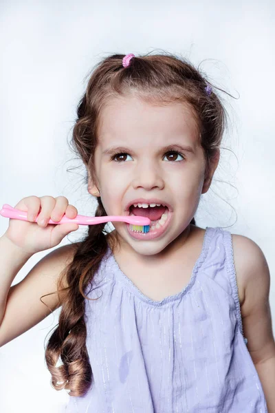 Little kid girl cleaning teeth by toothbrush, dental care concept.