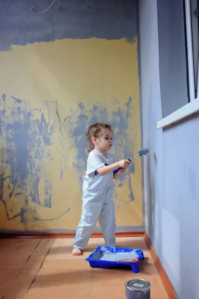 Petite fille enfant peint mur par rouleau de peinture — Photo