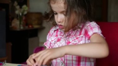 Evde yapbozla oynayan sevimli küçük bir kızın görüntüleri.