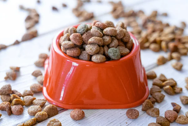 Fresh and natural dry pet food in a orange plastic bowl.