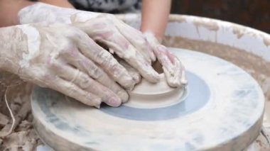 Potter çömlek çarkında tabak oluşturuyor.