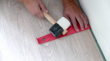 Marangoz ekipmanla parke döşemesini monte ediyor