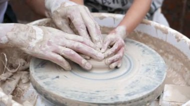 Potter çömlek çarkında tabak oluşturuyor.