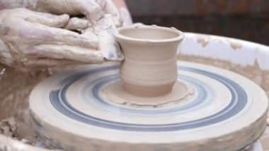 Potter çömlek çarkında tabak oluşturuyor.