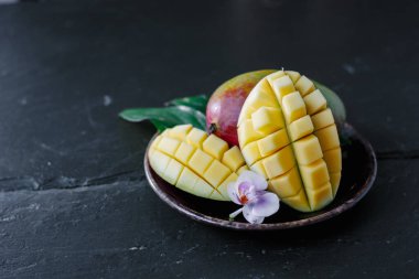 Arkaplanda seramik tabakta mango meyveleri