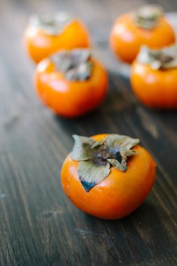 Taze portakal hurmaları ahşap masada.