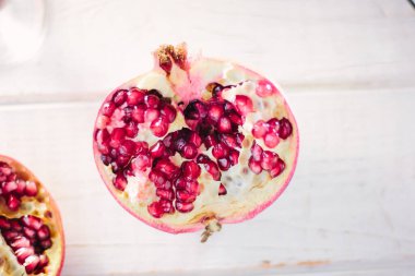 Beyaz ahşap yüzey üzerinde nar meyvesinin yarısı