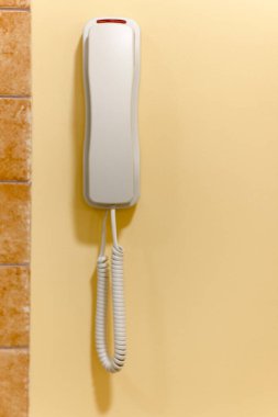 Duvardaki beyaz plastik telefon acil çağrı ya da destek için.