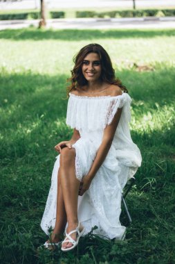 Güzel gelin oturuyor ve fotoğraf çekimi sırasında dinleniyor.