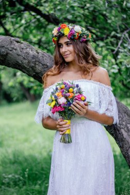 Yaşlı ağacın yanındaki yeşil ormanda güzel bir gelin