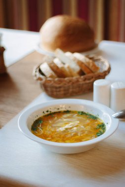 Masadaki beyaz seramik tabakta çorba.