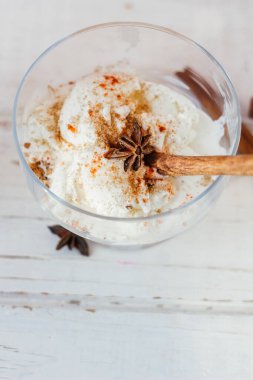 Ahşap masanın üzerinde cam kasede nefis beyaz dondurma.