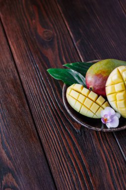 Taze olgun mango yaprakları ve ahşap masanın üzerinde çiçek..