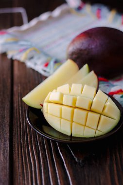 Mango, tahta masanın üzerinde küp şeklinde kesilmiş..