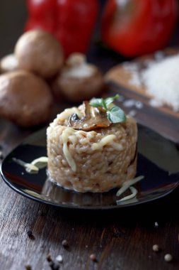 Siyah seramik tabakta İtalyan mantarlı risotto.
