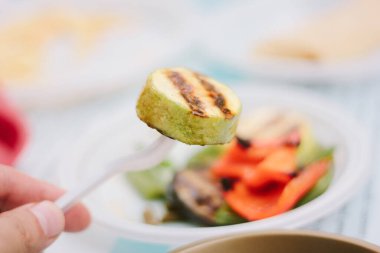 Kafedeki plastik çatalda ızgara sebze.