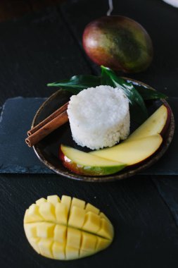 Seramik tabakta pirinçli mango meyveleri.