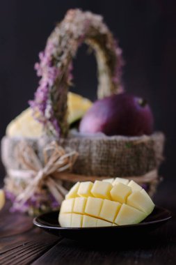 Taze ve sulu mango, ahşap masanın üzerinde ikiye bölünmüş.