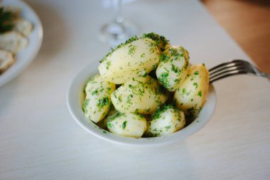 Genç patatesler, restoran masasındaki otlarla kaynıyor.