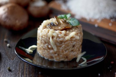 Siyah seramik tabakta İtalyan mantarlı risotto.