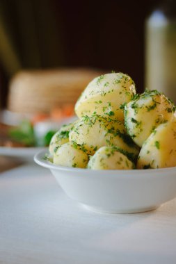 Genç patatesler, restoran masasındaki otlarla kaynıyor.