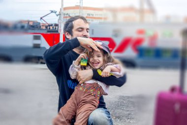 Babam kızıyla tren istasyonunda oynuyor..