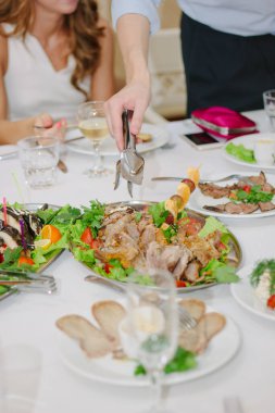 Elleri maşalı Noel hindisini yemek için ayırır.