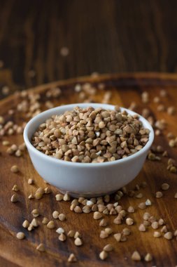 Tahta masanın üzerinde seramik kasede karabuğday taneleri