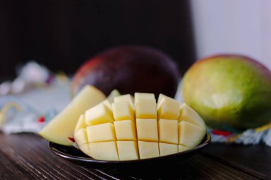 Mango, tahta masanın üzerinde küp şeklinde kesilmiş..