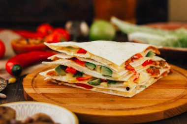 Tortilla ekmeği, fasulye, peynir ve sebzeli vejetaryen quesadilla.