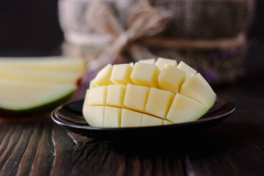 Taze ve sulu mango, ahşap masanın üzerinde ikiye bölünmüş.