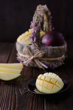 Taze ve sulu mango, ahşap masanın üzerinde ikiye bölünmüş.