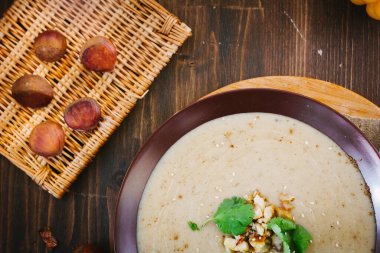 Kahverengi tabakta sebzeli kestane kremalı çorba.