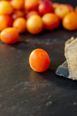 Taze ve olgun yaban eriği veya siyah yüzeyde kiraz eriği