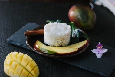 Seramik tabakta pirinçli mango meyveleri.