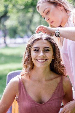 Parktaki genç bayan için güzel bir saç stili yaratıyorsun.