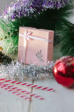 Yeni yıl hediyeleri ve beyaz tahta üzerinde hediyelerle dolu bir kutu.