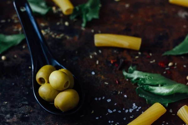 Olivy Černé Lžíci Obklopené Dalšími Ingrediencemi — Stock fotografie